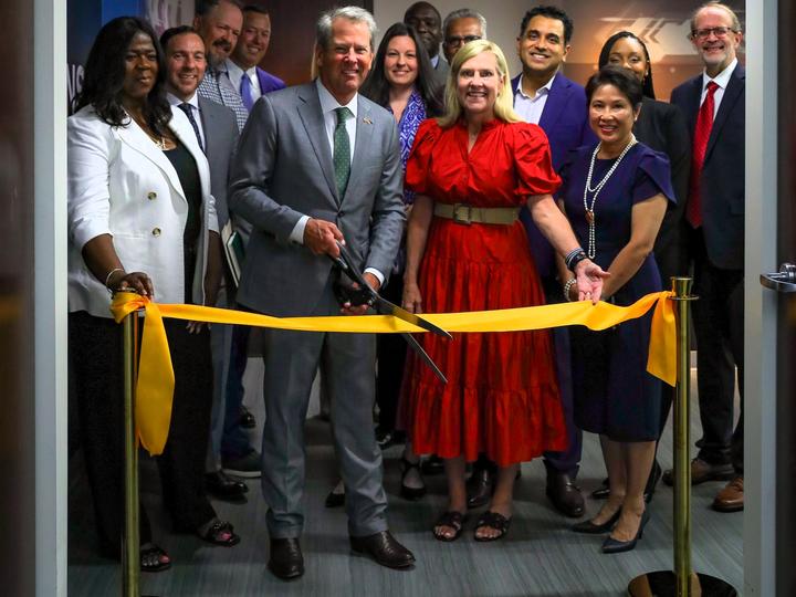 Governor Brian Kemp First Lady Marty Kemp hold large scissors over a ribbon while standing with Georgia Technology Authority leadership
